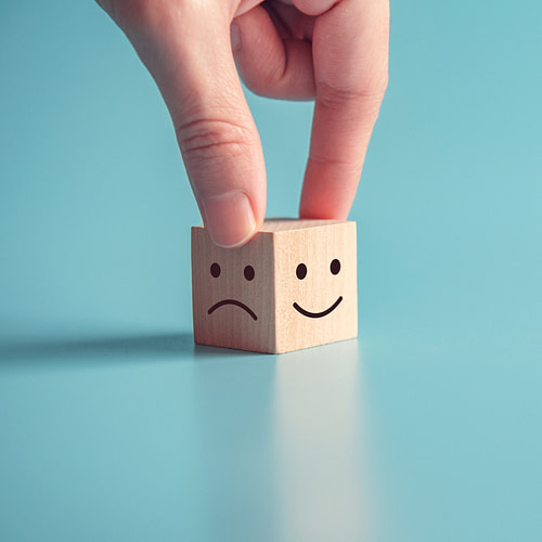 close-up-customer-hand-choose-smiley-face-sad-face-icon-wood-cube